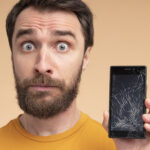 portrait-shocked-young-man-showing-his-broken-smartphone portrait-shocked-young-man-showing-his-broken-smartphone