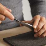 Computer and phone repairment service Techician uses driver to unscrew small screws on smartphone body